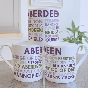 A stack of three Aberdeen mugs, printed with the names of areas and neighbourhoods in Aberdeen, in a kitchen