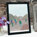 Hiking print - an illustration of seven hikers heading in to the hills - in a black frame standing on a shelf